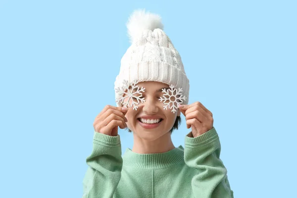 色の背景に雪の結晶を持つ美しい若い女性 — ストック写真