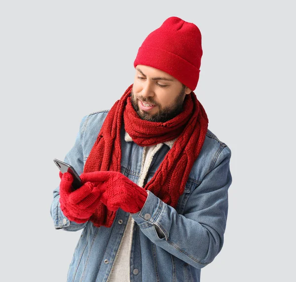Schöner Mann Winterkleidung Und Mit Handy Auf Hellem Hintergrund — Stockfoto