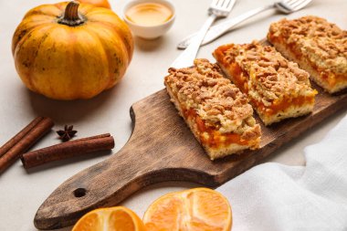 Beyaz arka planda lezzetli balkabağı turtası olan ahşap tahta, yakın plan.