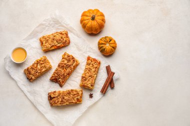 Beyaz arkaplanda lezzetli balkabağı turtası parçaları olan parşömen.