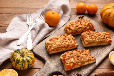 Ahşap zemin üzerinde lezzetli balkabağı turtası parçaları olan tahta.