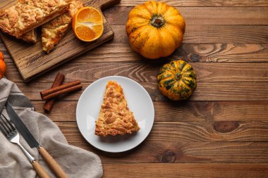 Ahşap zemin üzerinde lezzetli balkabağı turtası olan tabak ve yemek.