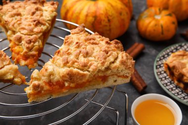 Siyah zemin üzerinde lezzetli balkabağı turtası parçaları olan şebeke, yakın plan.