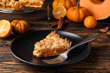 Ahşap zemin üzerinde taze balkabağı turtası olan bir tabak.