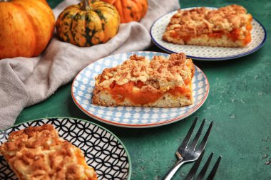 Yeşil zemin üzerinde lezzetli balkabağı turtası olan tabaklar