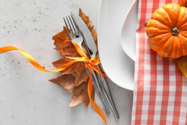 Masa düzeniyle kompozisyon, balkabağı ve sonbahar yaprakları beyaz arkaplanda