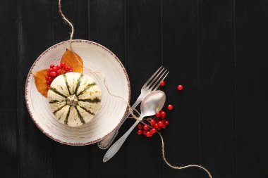 Masa düzeniyle kompozisyon ve siyah ahşap arka planda balkabağı