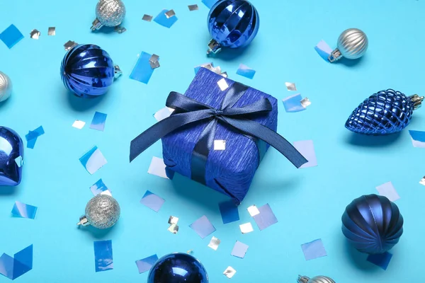 Komposition Mit Weihnachtsgeschenkschachtel Und Kugeln Auf Blauem Hintergrund — Stockfoto