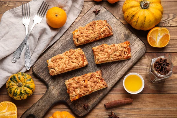 Ahşap zemin üzerinde lezzetli balkabağı turtası parçaları olan tahta.