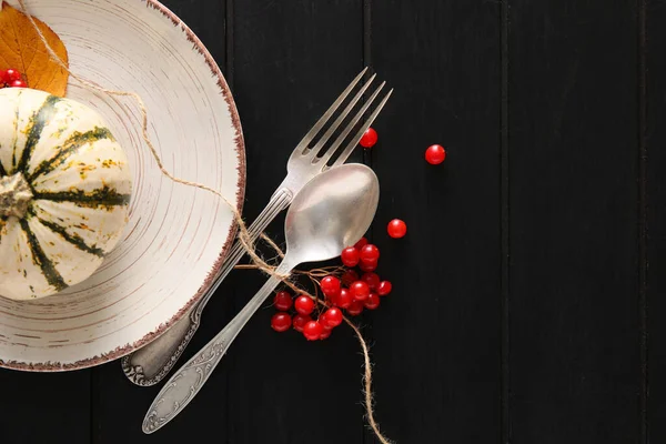 Masa düzeniyle kompozisyon ve siyah ahşap arka planda balkabağı