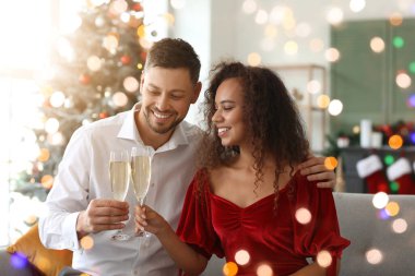Mutlu çift ve şampanya Noel 'i evde kutluyor.