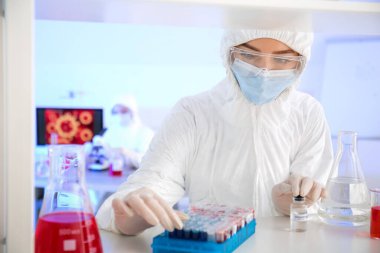Laboratuvarda numunelerle çalışan bir bilim adamı
