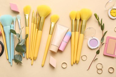 Renk arkaplanında makyaj fırçası olan dekoratif kozmetik seti