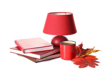 Kitap yığını, lamba, bir fincan kahve ve sonbahar yaprakları beyaz arka planda