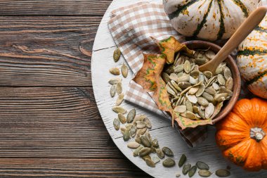 Ahşap zemin üzerinde kabak tohumları olan bir kase
