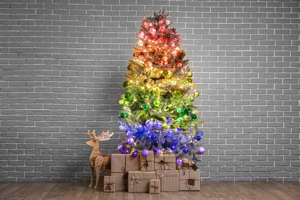 Árbol Navidad Arco Iris Con Regalos Cerca Pared Ladrillo Concepto — Foto de Stock