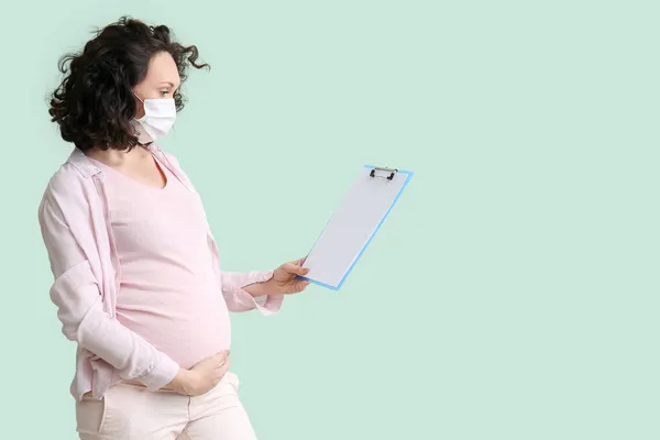 Young Pregnant Woman Medical Mask Clipboard Color Background — Stock Photo, Image