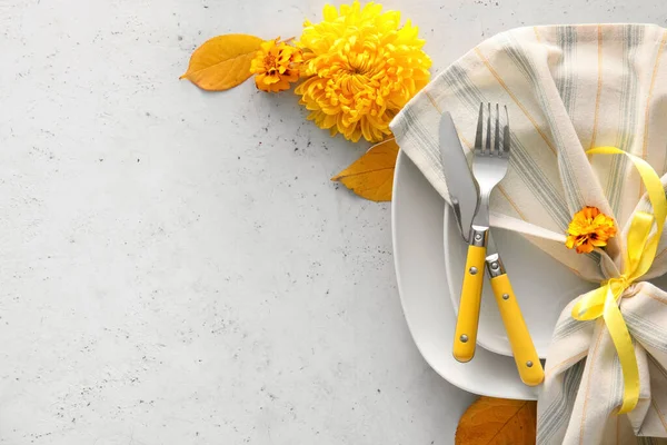 Masa düzeniyle kompozisyon ve beyaz arkaplanda kasımpatı çiçekleri