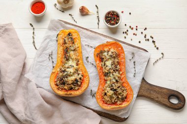 Beyaz ahşap arka planda içi doldurulmuş balkabaklarıyla dolu bir tahta.