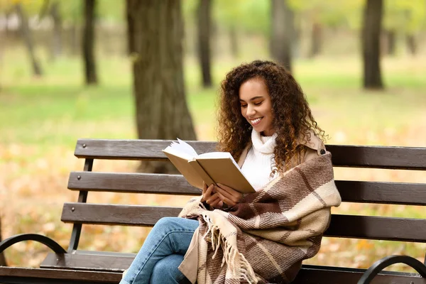 Genç Afro Amerikalı Kadın Sonbahar Parkında Bankta Sıcak Ekoseli Kitap — Stok fotoğraf