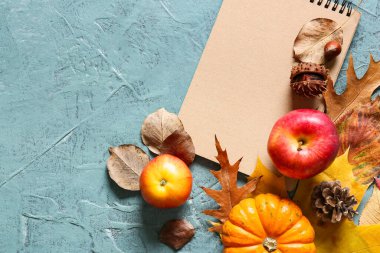 Renk arkaplanında defter, elma, balkabağı ve sonbahar yaprakları olan kompozisyon