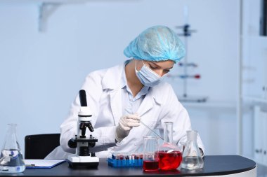 Bilimadamı laboratuvarda örnek üzerinde çalışıyor.