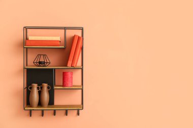 Renk duvarında kitap ve dekor olan modern raf