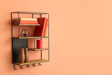 Renk duvarında kitap ve dekor olan modern raf