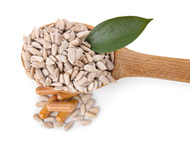 Ayçiçeği tohumlu kaşık ve beyaz arka planda haplar