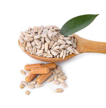 Ayçiçeği tohumlu kaşık ve beyaz arka planda haplar