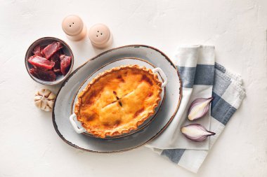 Beyaz arka planda malzemeleri olan lezzetli etli börek.