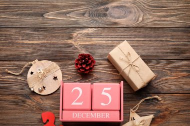 Noel tarihli takvim, hediye kutusu ve ahşap arka planda süslemeler