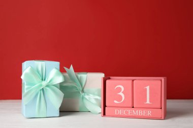 Yeni yıl tarihli takvim ve renk arkaplanına karşı hediye kutuları