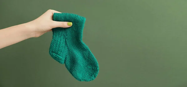 Γυναικείο Χέρι Ζεστή Κάλτσα Πράσινο Φόντο Χώρο Για Κείμενο — Φωτογραφία Αρχείου