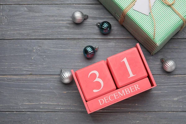 グレーの木製の背景に12月31日 装飾やギフトボックスの日付とカレンダー — ストック写真