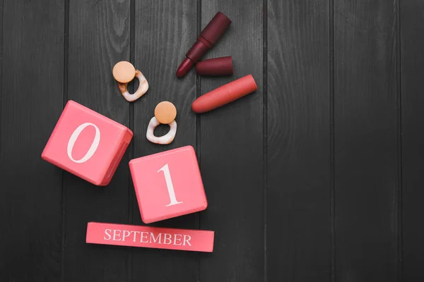 カレンダー9月1日の日付 イヤリングや暗い木製の背景に口紅 — ストック写真