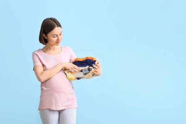 Young Pregnant Woman Holding Basket Baby Clothes Blue Background — Stock Photo, Image