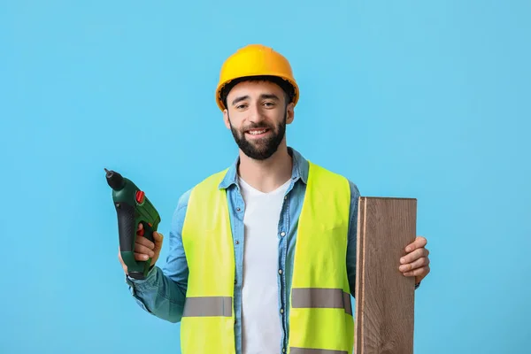 Trabalhador Construção Civil Com Pistola Parafuso Pranchas Madeira Fundo Azul — Fotografia de Stock