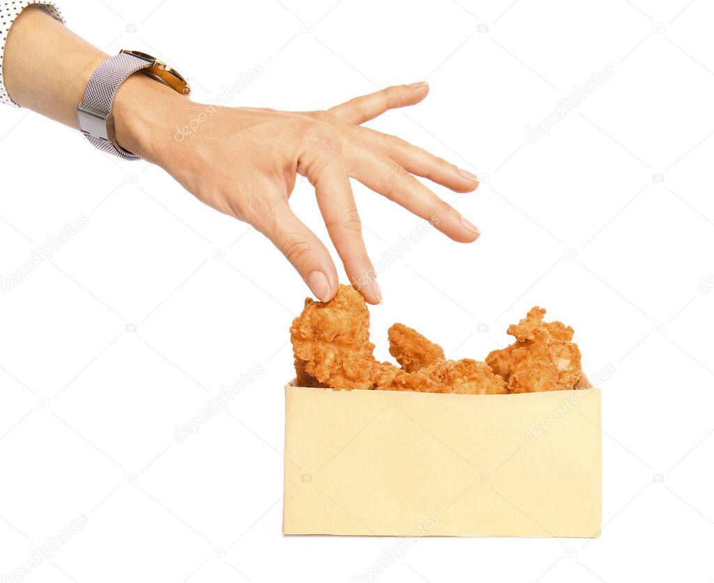 Woman taking tasty deep fried chicken wing from paper box on white background