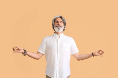 Renkli arka planda olgun bir adam meditasyonu