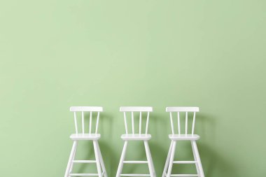 Yeşil arka plandaki çocuklar için beyaz sandalyeler