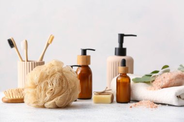 Sünger, banyo malzemeleri ve havlu ışık masasında.