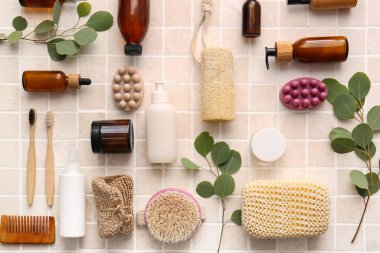 Süngerli banyo malzemeleri ve bej fayansların üzerine ağaç dalları.