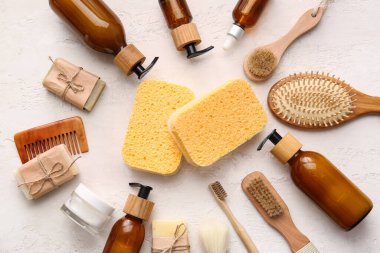 Beyaz arka planda süngerli ve masaj fırçalı banyo malzemeleri.