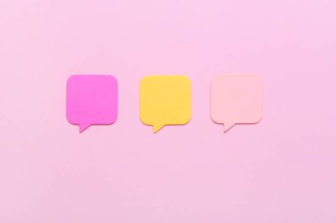 Pembe arkaplanda renkli yapışkan notlar