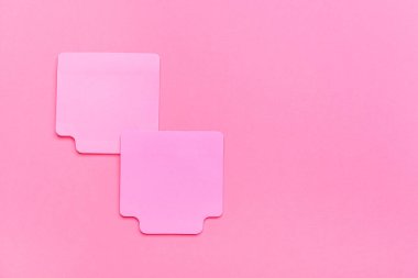 Pembe arka plan üzerine yapışkan not kağıtları