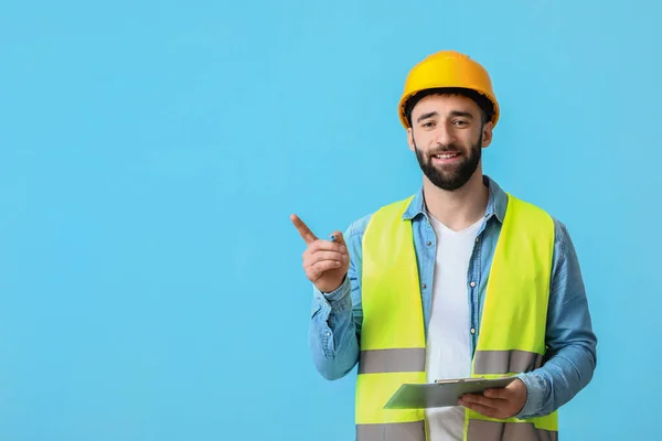 Trabajador Construcción Con Portapapeles Apuntando Algo Sobre Fondo Azul —  Fotos de Stock