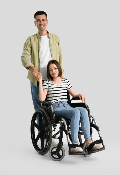 坐轮椅的年轻妇女和她背景浅的丈夫 — 图库照片