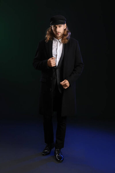 Красивый стильный молодой человек на черном фоне