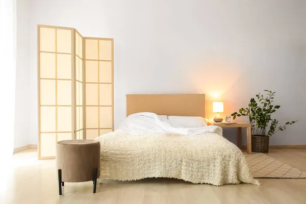 Stylish folding screen in bedroom interior